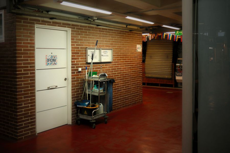 Janitorial cart in a bright commercial hallway outside an office door